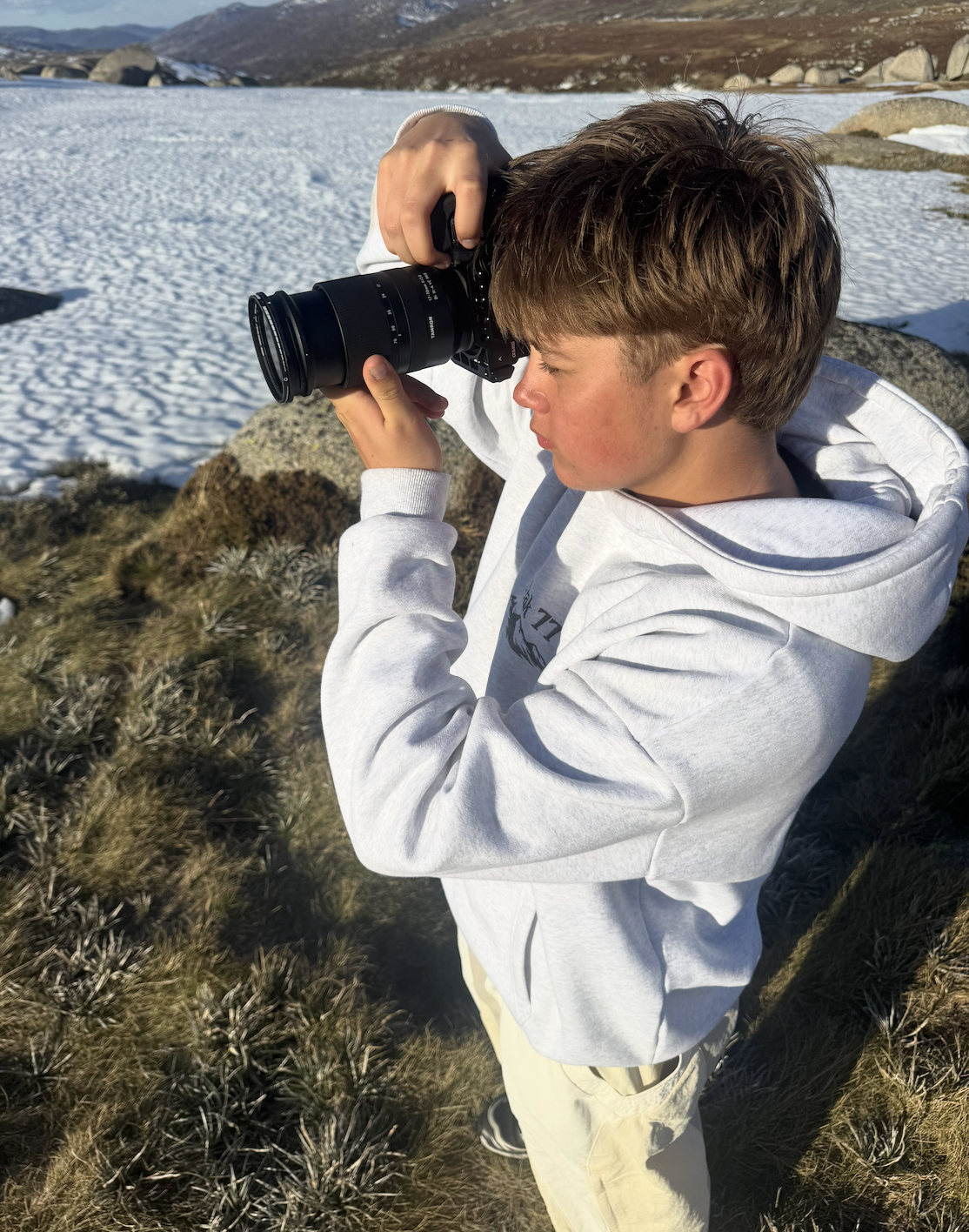 Finn filming with a Sony a6700 and Tamron 17-70mm lens in the snowy mountains